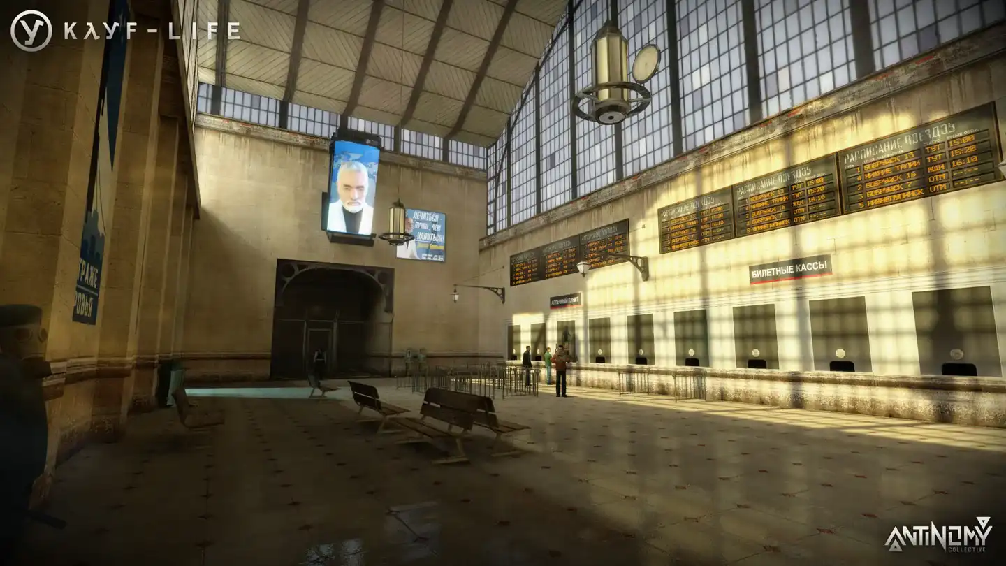 Official KAYF-LIFE screenshot showing a railway-station hall with ticket counters, benches, and timetable boards